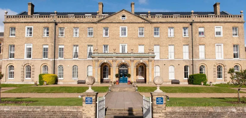 L'imponente edificio principale del St. Edmund’s College è circondato da giardini ben curati con percorsi in pietra e vasi decorativi.