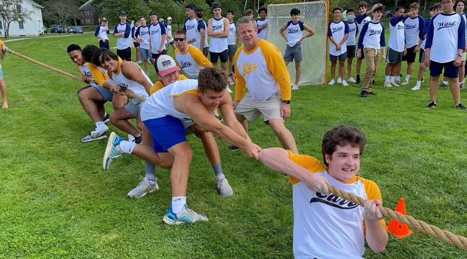 Studenti della The Salisbury School partecipano a un'attività di team building su un prato.