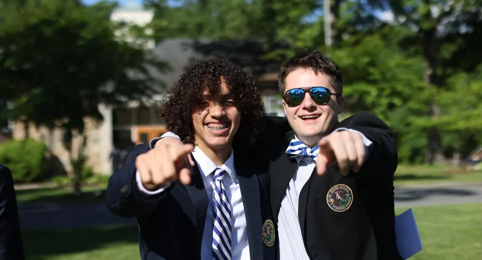 Due studenti della Blue Ridge School si trovano all'aperto davanti agli alberi e sorridono alla telecamera.