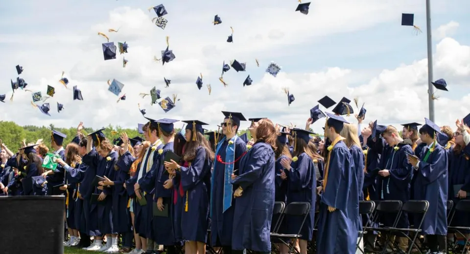Un gruppo di diplomati della Essex District High School lancia in aria i tocchi durante la cerimonia di diploma.