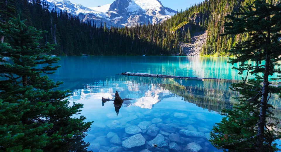 Il lago alpino con montagne innevate e bosco verde nei pressi della H.J. Cambie Secondary School.