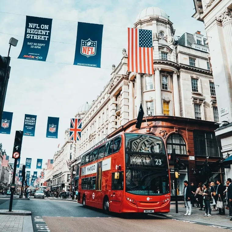 Roter Doppeldeckerbus auf der Regent Street in London mit Flaggen und Bannern