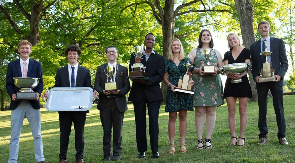 Un gruppo di studenti della St. Andrew's-Sewanee School all'aperto con riconoscimenti e trofei in mano.