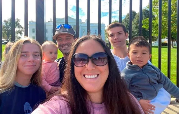 Una familia haciéndose un selfie frente a las rejas con la Casa Blanca al fondo