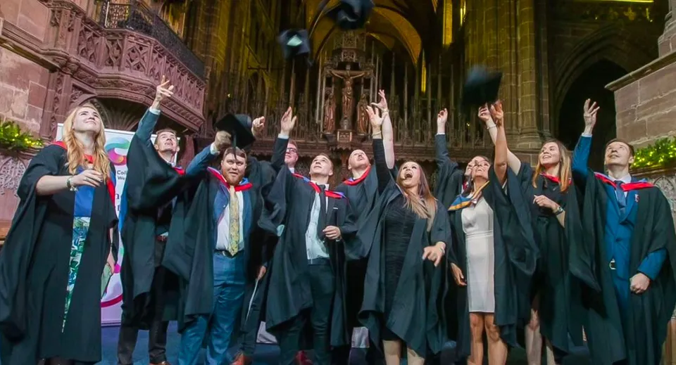 I neodiplomati del Cheshire College South & West festeggiano la loro cerimonia di diploma in una splendida sala simile a una cattedrale.