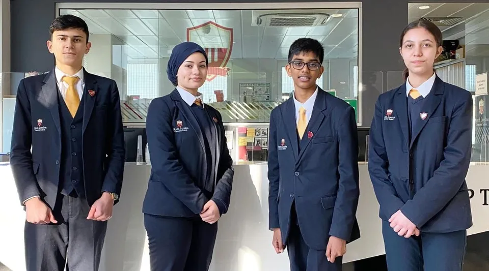Quattro studenti e studentesse della North London Grammar School si trovano nel corridoio della scuola.