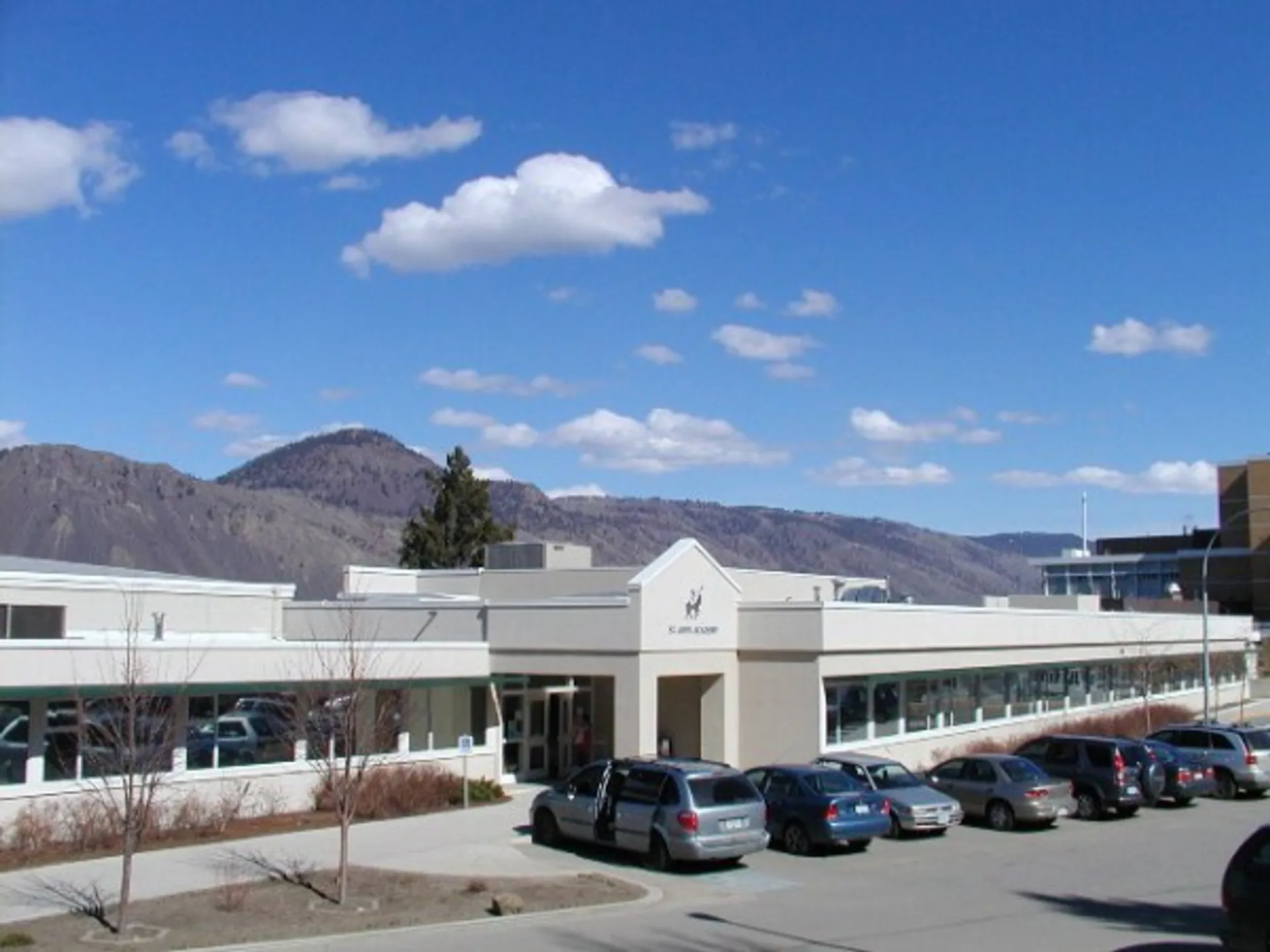 L'edificio scolastico della St Ann's Academy con un parcheggio antistante e montagne sullo sfondo.