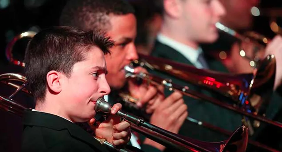Studenti della Mill Hill International suonano il trombone in un'orchestra.