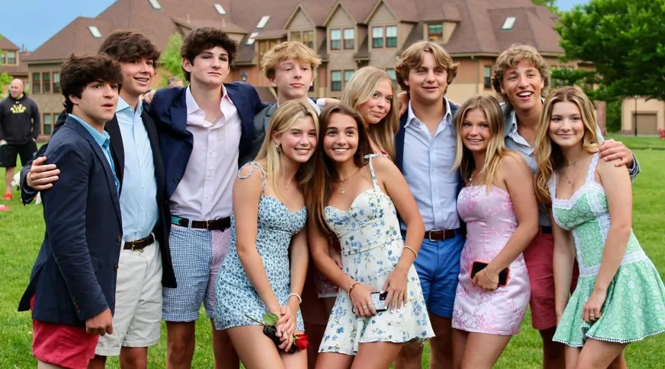 Un gruppo di studenti e studentesse è in piedi davanti a un edificio dall'architettura caratteristica nel campus della Westminster School.