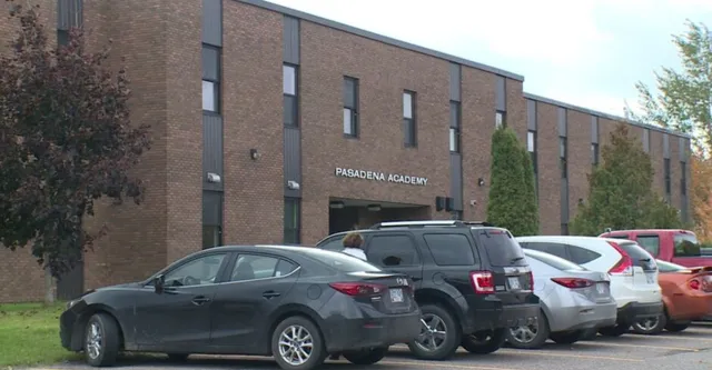 El gran edificio de ladrillo de la Pasadena Academy con coches aparcados en primer plano.