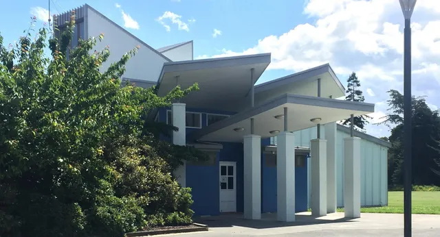 L'edificio moderno del Central Southland College con grandi finestre e un ingresso circondato dal verde sotto un cielo azzurro.