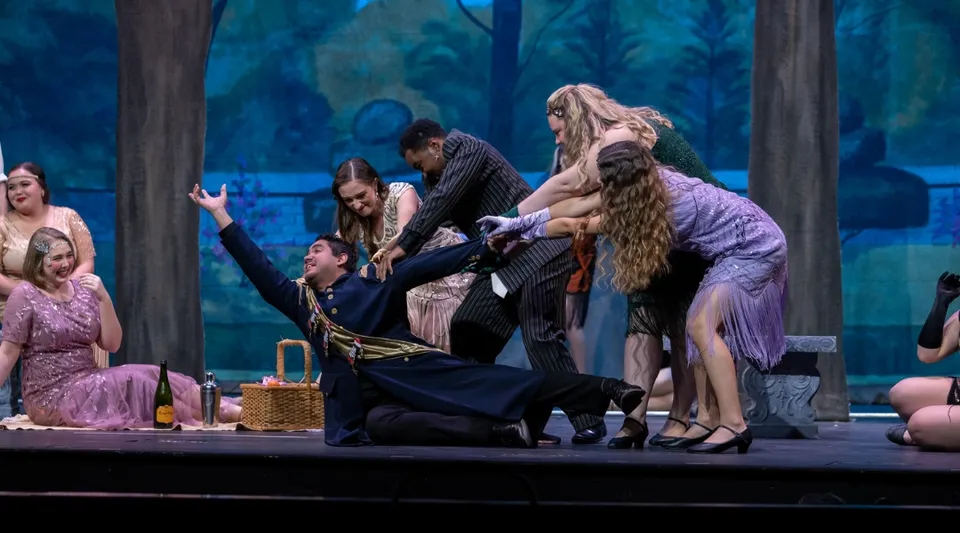 Studenti della University of North Florida mettono in scena uno spettacolo teatrale su un palco con una scenografia di bosco mistico.