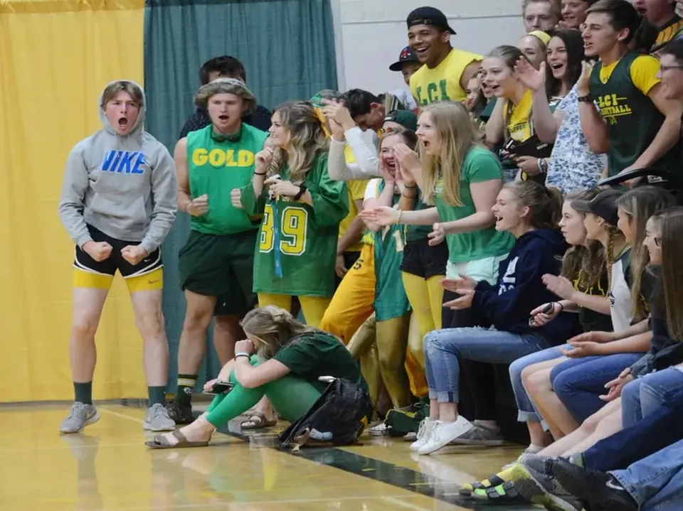 Studenti del Lethbridge Collegiate Institute festeggiano insieme in divisa sportiva in una palestra.