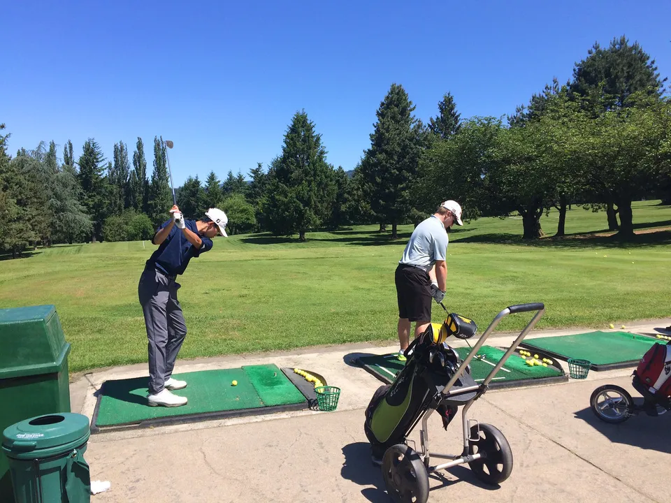 Due golfisti si trovano sul campo da golf immerso nel verde nel campus della David Thompson Secondary School.