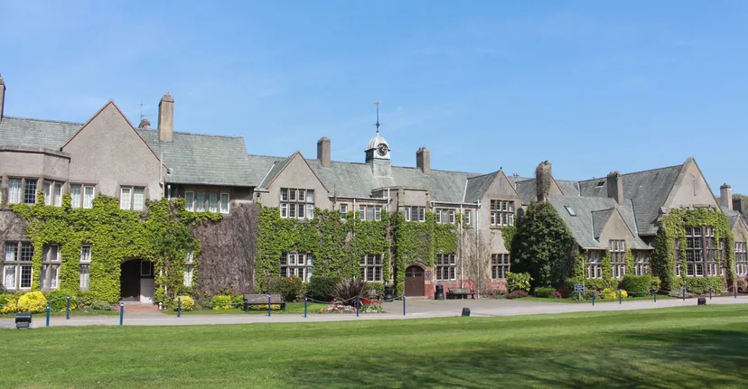 Il campus della Kirkham Grammar School mostra un edificio principale storico con torre e un grande prato verde in primo piano.