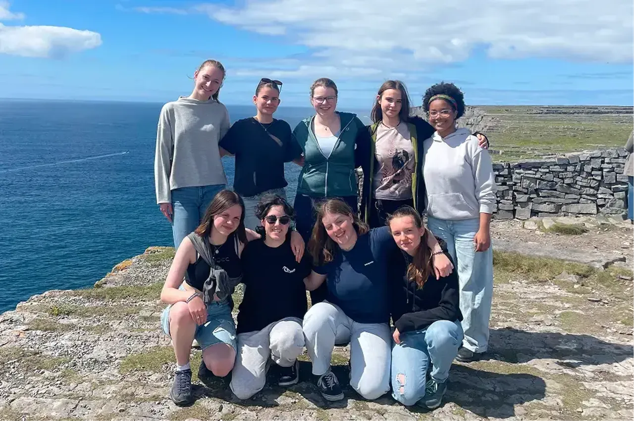 Gruppo di studentesse in posa su una scogliera irlandese affacciata sul mare