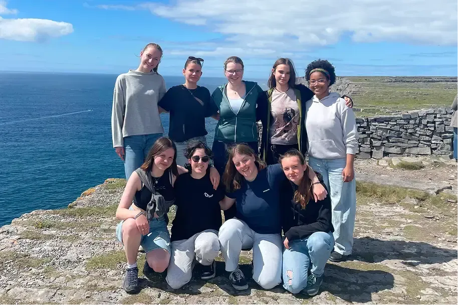 Gruppo di studentesse in posa su una scogliera irlandese affacciata sul mare