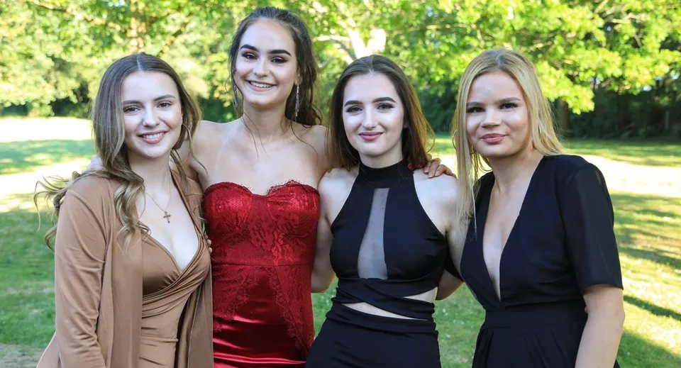 Quattro studentesse della St. Mary's Secondary School a Macroom posano insieme nell'area verde esterna.