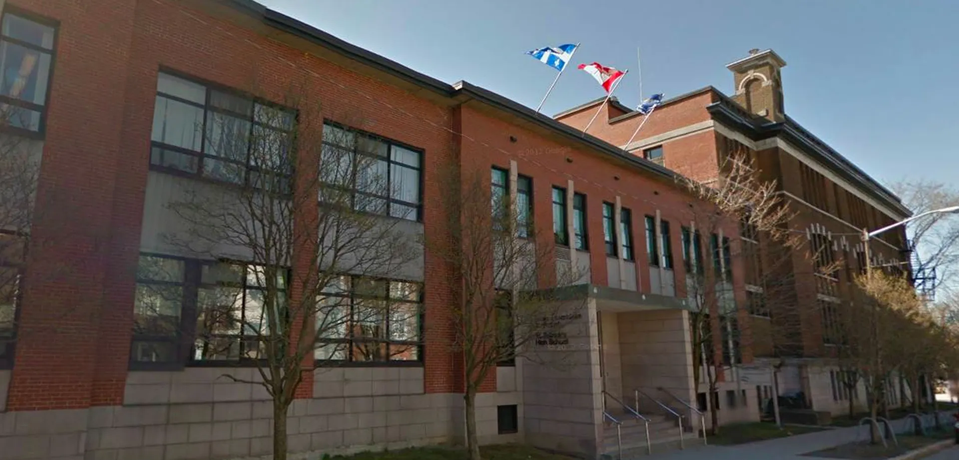 L'edificio in mattoni rossi della St. Patrick’s High School con bandiere sul tetto.