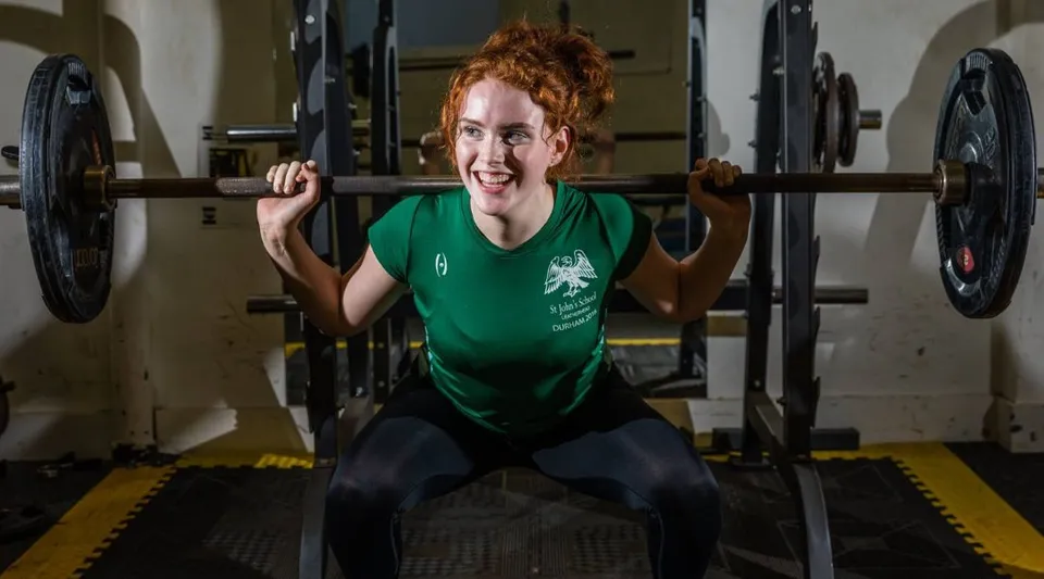 Una persona solleva pesi nella sala fitness della St. John’s School a Leatherhead.