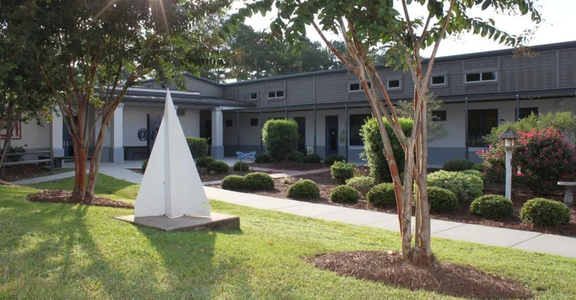 L'edificio moderno a due piani con una struttura triangolare bianca si trova nel curato campus della Pinewood Preparatory School.