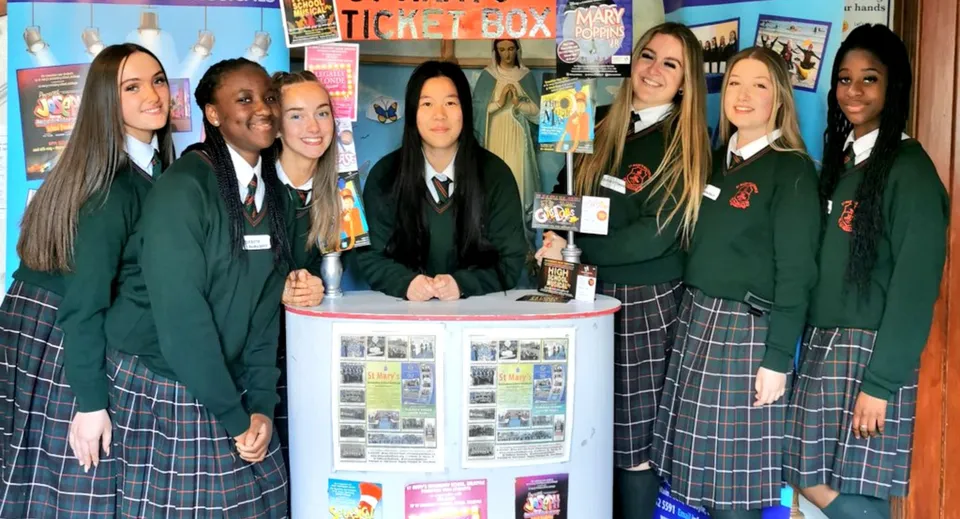 Un gruppo di studenti e studentesse della St. Mary’s Secondary School (Baldoyle) si trova davanti a un tabellone informativo con materiale scolastico.
