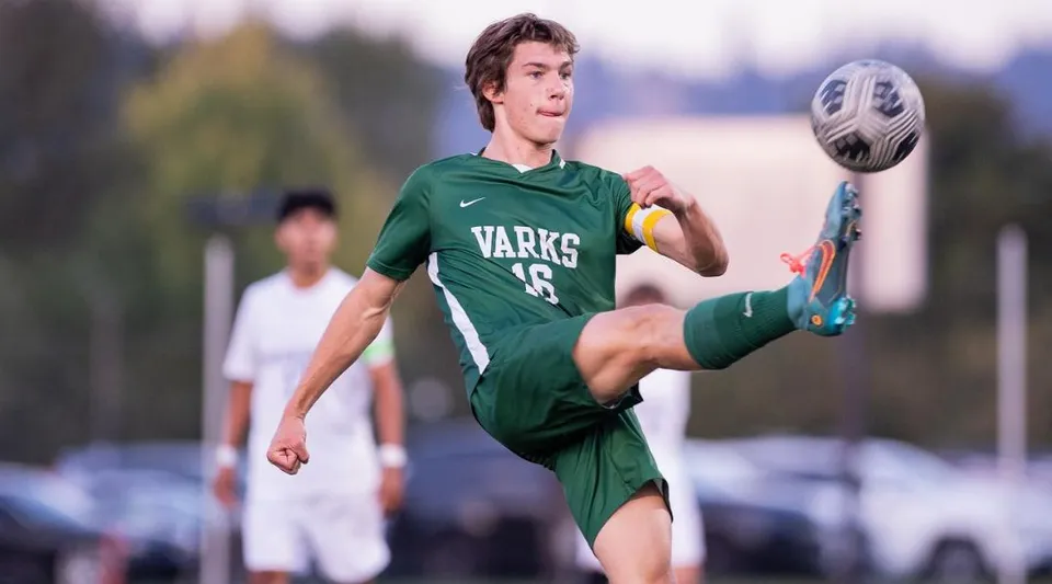 Un alunno della Oregon Episcopal School calcia un pallone da calcio sul campo sportivo durante una partita.