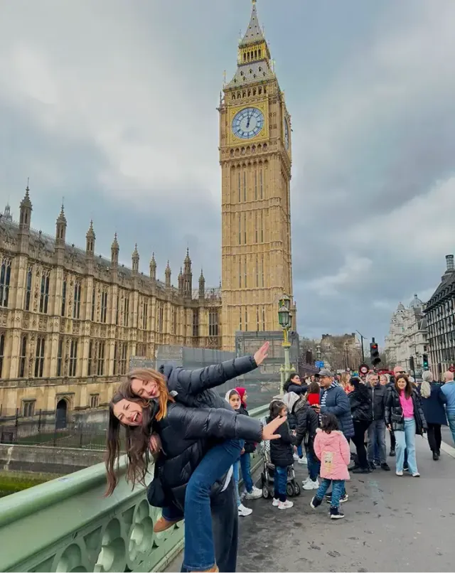 Due amiche ridono davanti al Big Ben e al Palazzo di Westminster a Londra