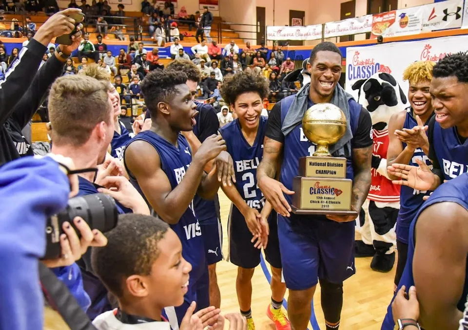 La squadra di pallacanestro del Bella Vista College Prep festeggia con un trofeo in palestra.