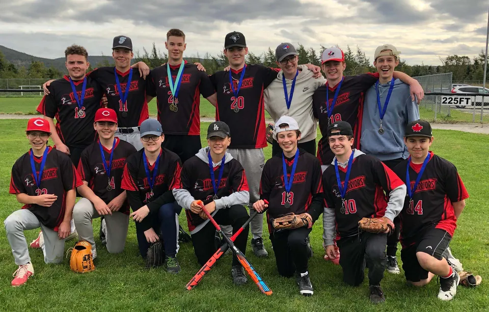 Un gruppo di giovani atleti posa sul campo sportivo della Waterford Valley High School davanti a un paesaggio montano.