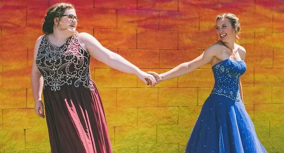 Due donne in abiti eleganti si tengono per mano a un evento della Chilliwack Secondary School.