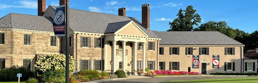 L'edificio principale della Saddle River Day School con colonne all'ingresso e un giardino ben curato.