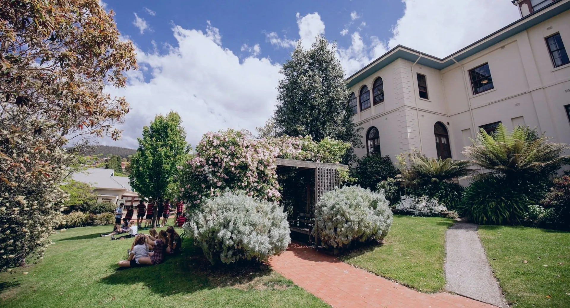 L'edificio a più piani della The Friends’ School è circondato da un giardino curato con diverse piante e alberi.