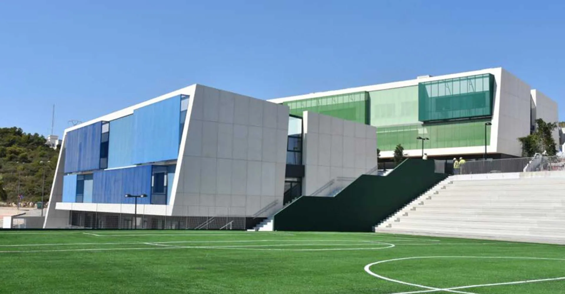 L'edificio moderno della Laude Lady Elizabeth School con un campo sportivo verde in primo piano sotto un cielo terso.