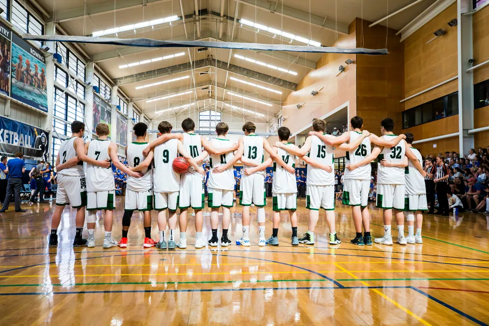 Un gruppo di giocatori di basket insieme sul campo da basket del Brisbane Boys' College.