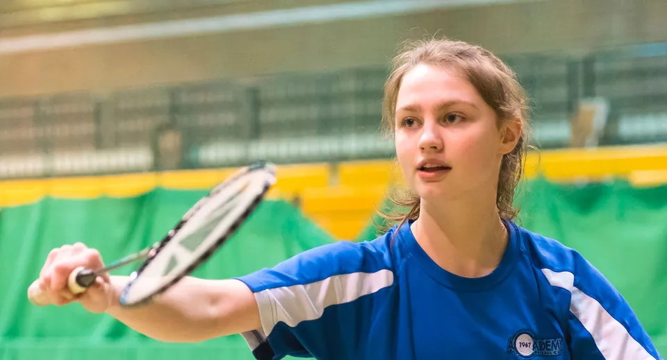 Una studentessa della MPW London gioca una partita di tennis sul campo da tennis verde della scuola.