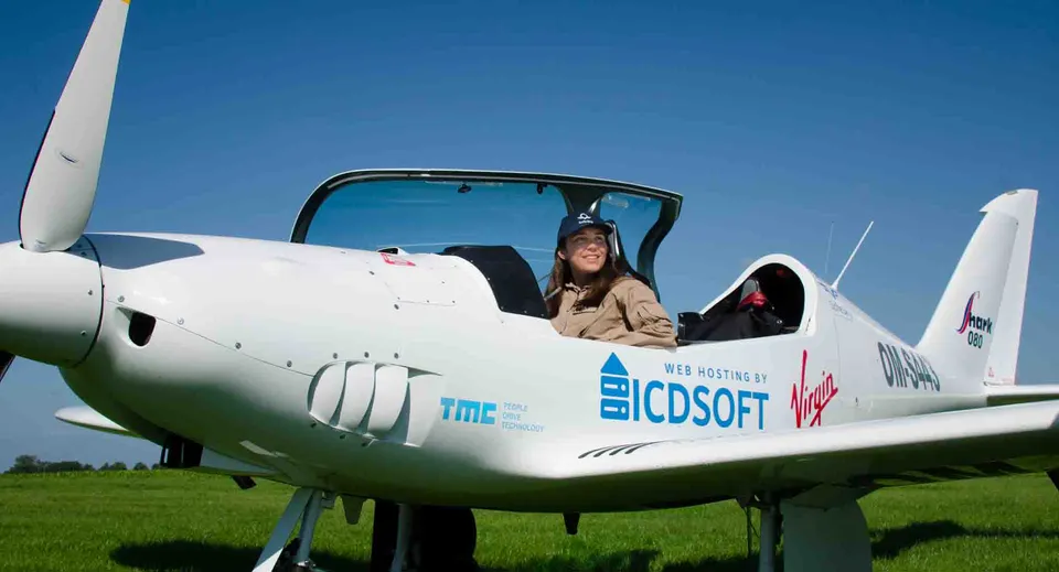 Una donna è seduta nel cockpit di un aereo bianco con il logo CDSOFT nel campus della St. Swithun's.