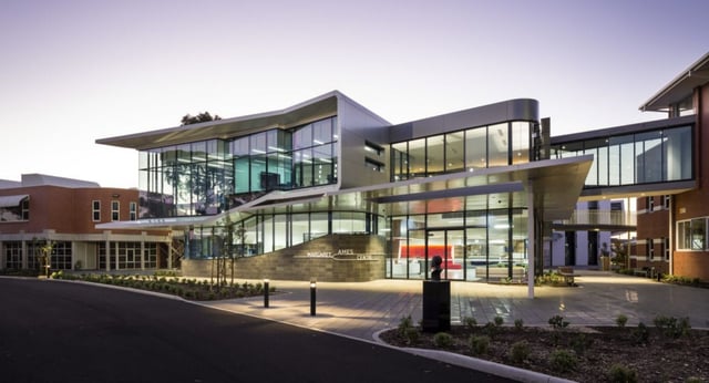 Das Immanuel College zeigt ein modernes Gebäude mit Glasfront und einer markanten Architektur, umgeben von angelegten Gärten.