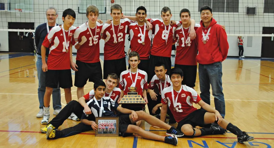 Un gruppo di studenti della Fraser Heights Secondary School posa con un trofeo in una palestra.