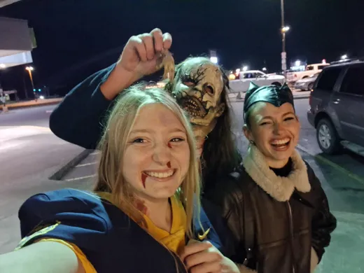 Tre ragazzi sorridenti in costume di Halloween per una foto notturna