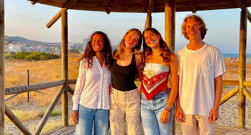 Un gruppo di quattro studenti si trova in un padiglione di legno con vista sul paesaggio costiero nel campus della Sotogrande International School.