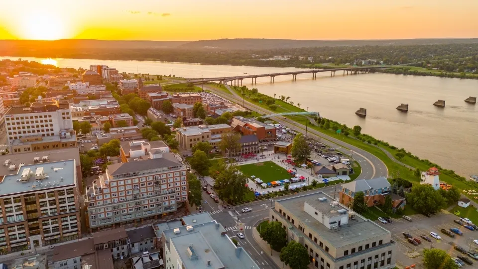 La vista della città con il fiume e le sponde verdi al tramonto mostra i dintorni del New Brunswick Community College.