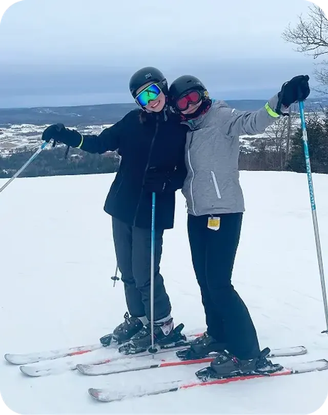Due ragazze con sci e caschi abbracciate su una pista innevata in Norvegia