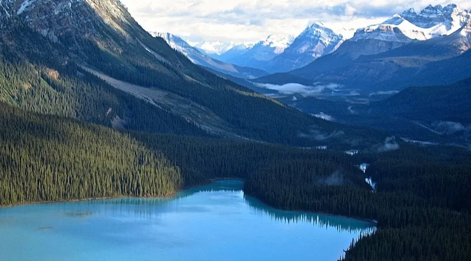 Un lago turchese circondato da montagne innevate e bosco di conifere sul terreno della Holy Trinity High School.