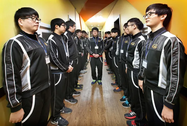Schüler der Daekyung Cultural Arts High School stehen in einheitlicher Trainingskleidung in zwei Reihen in einem Flur.