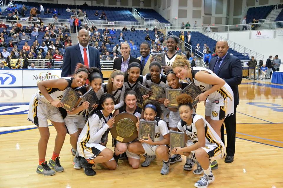 La squadra di pallacanestro femminile della Saint Anthony's High School posa con trofei in palestra.