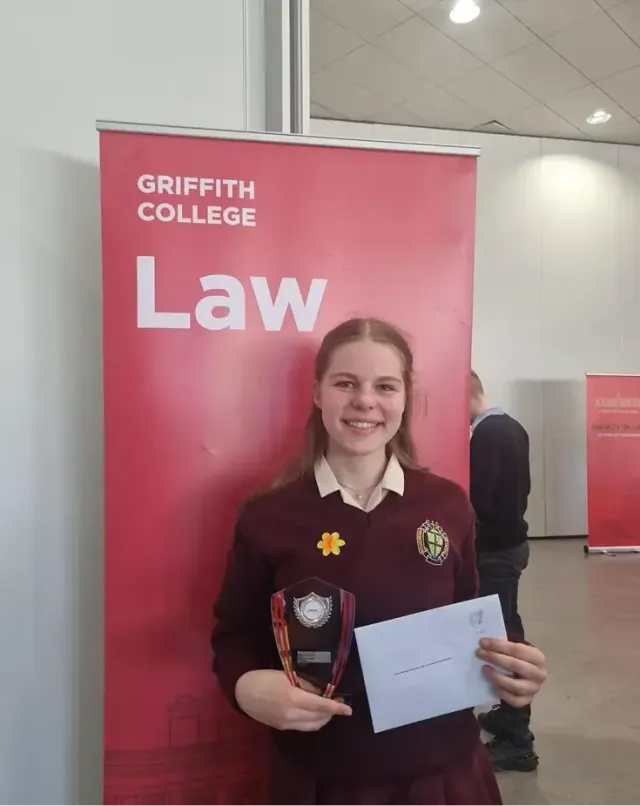 Studentessa in divisa con trofeo e attestato allo stand Griffith College Law durante una premiazione, in Irlanda