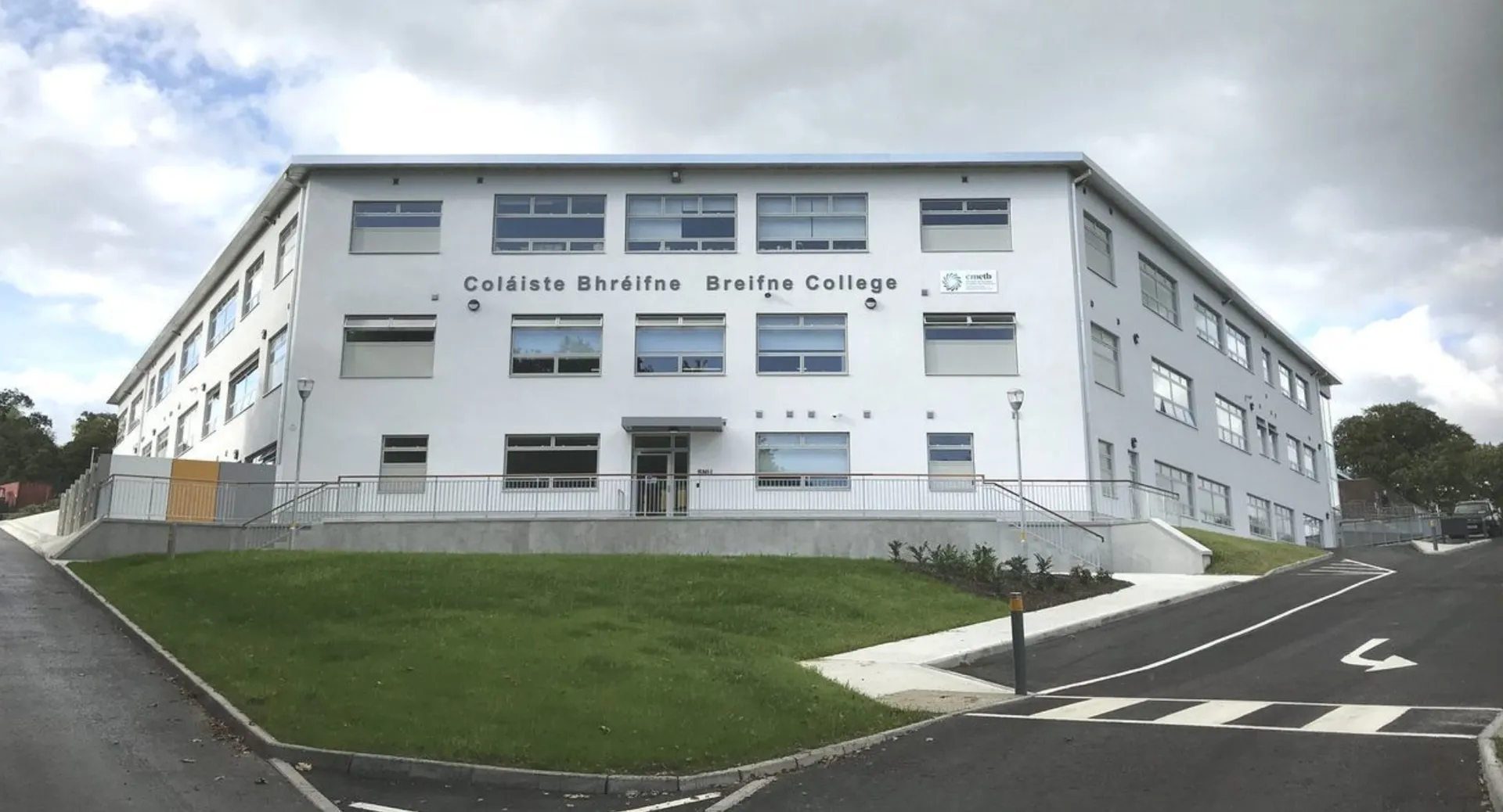 L'edificio moderno a più piani con grandi finestre nel campus del Breifne College è circondato da un'area erbosa e da un viale pavimentato.