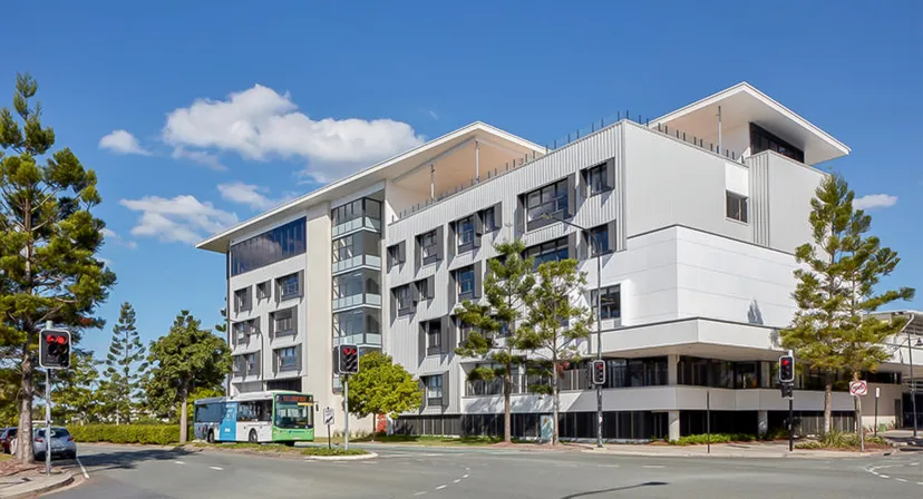 L'edificio moderno a più piani del North Lakes State College con aree residenziali e commerciali e il verde circostante.