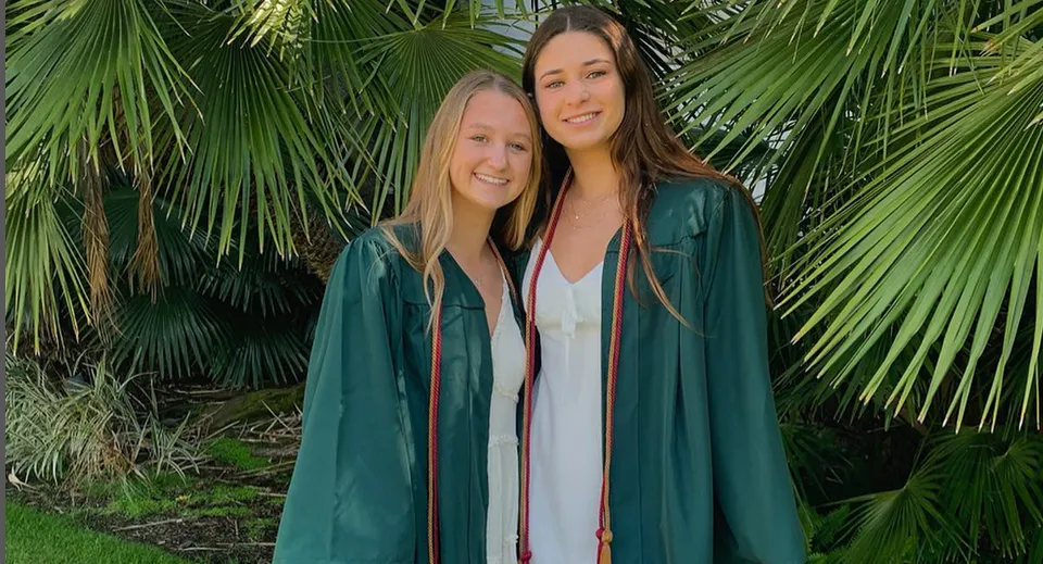 Due studentesse sono insieme in un ambiente tropicale con grandi foglie di palma all'interno del Santa Barbara Unified School District.